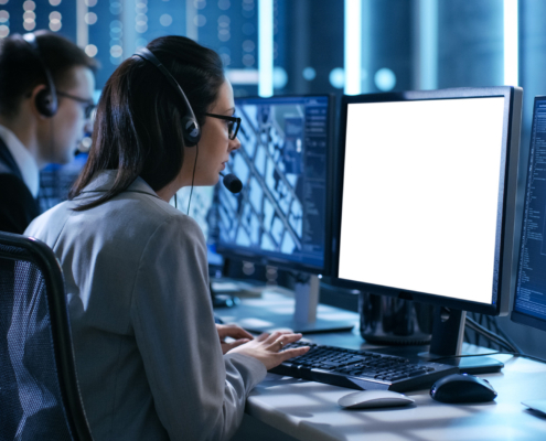 Emergency Dispatchers With Headsets Looking At Computers